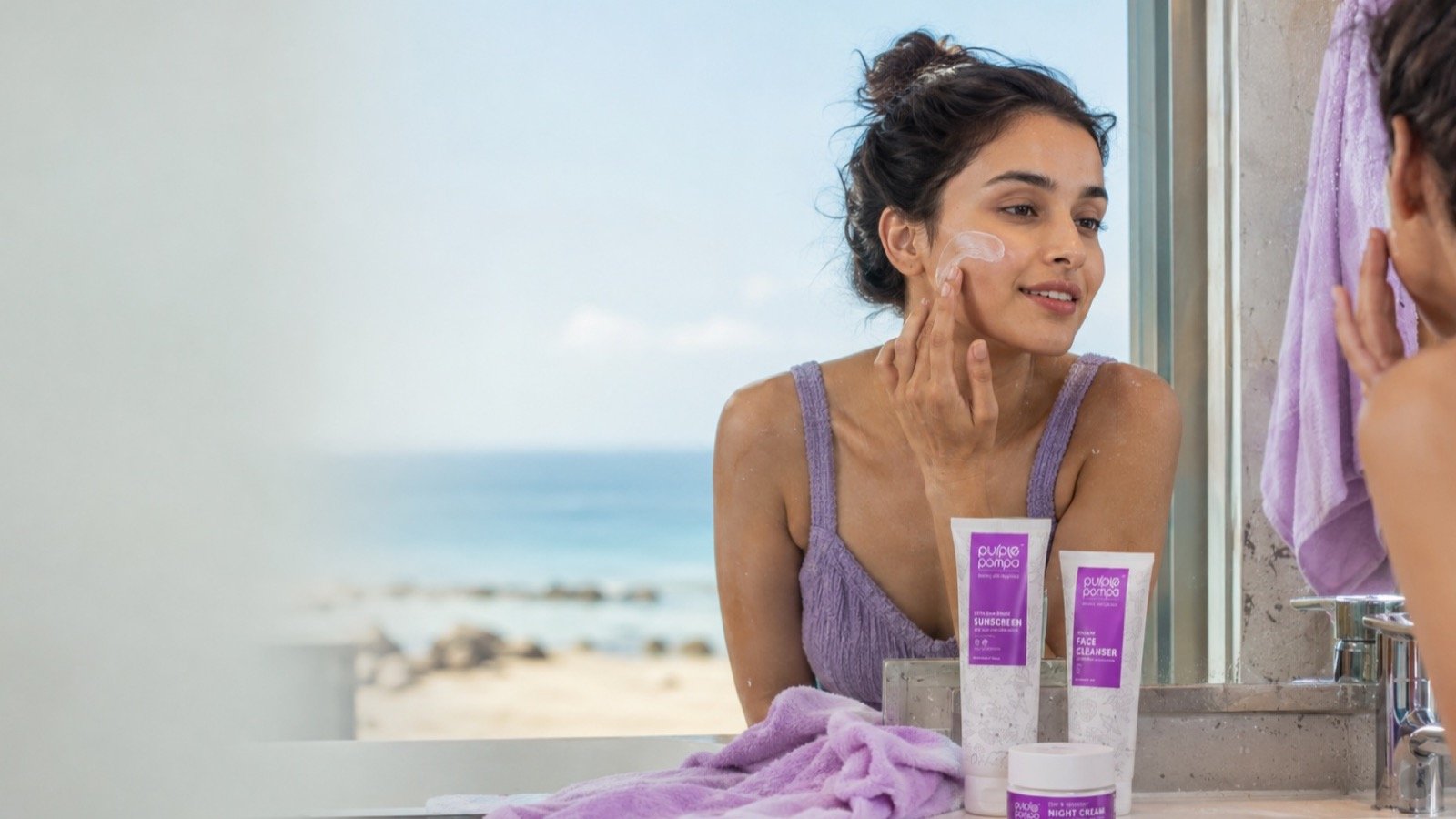 An Indian woman applying sunscreen beside Purple Pompa's marine skincare range